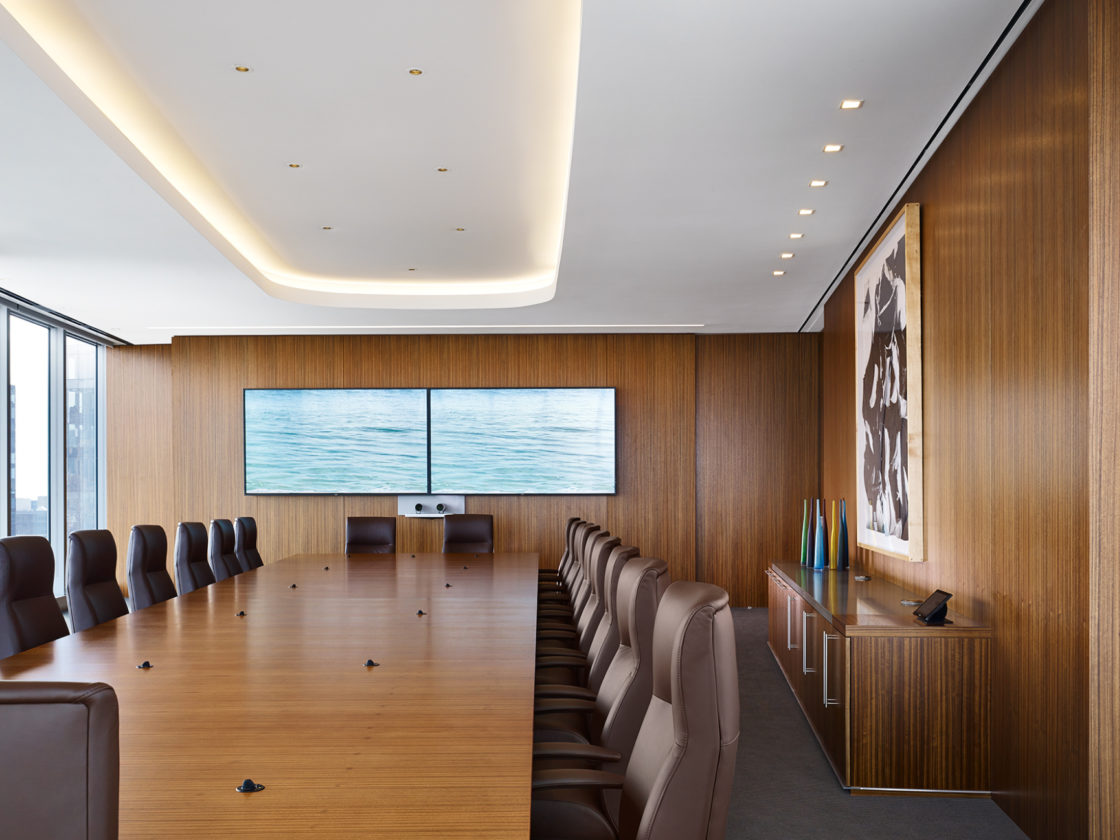 McDermott boardroom with seating around a conference table facing a monitor.